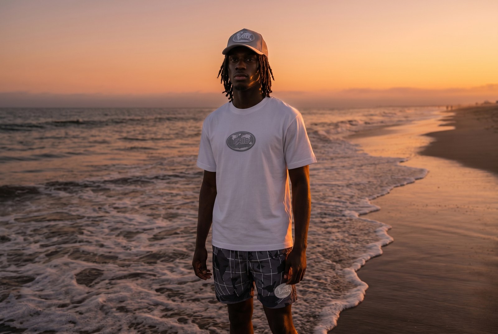 FAID summer drop, model wearing a black tee and patterned shorts.